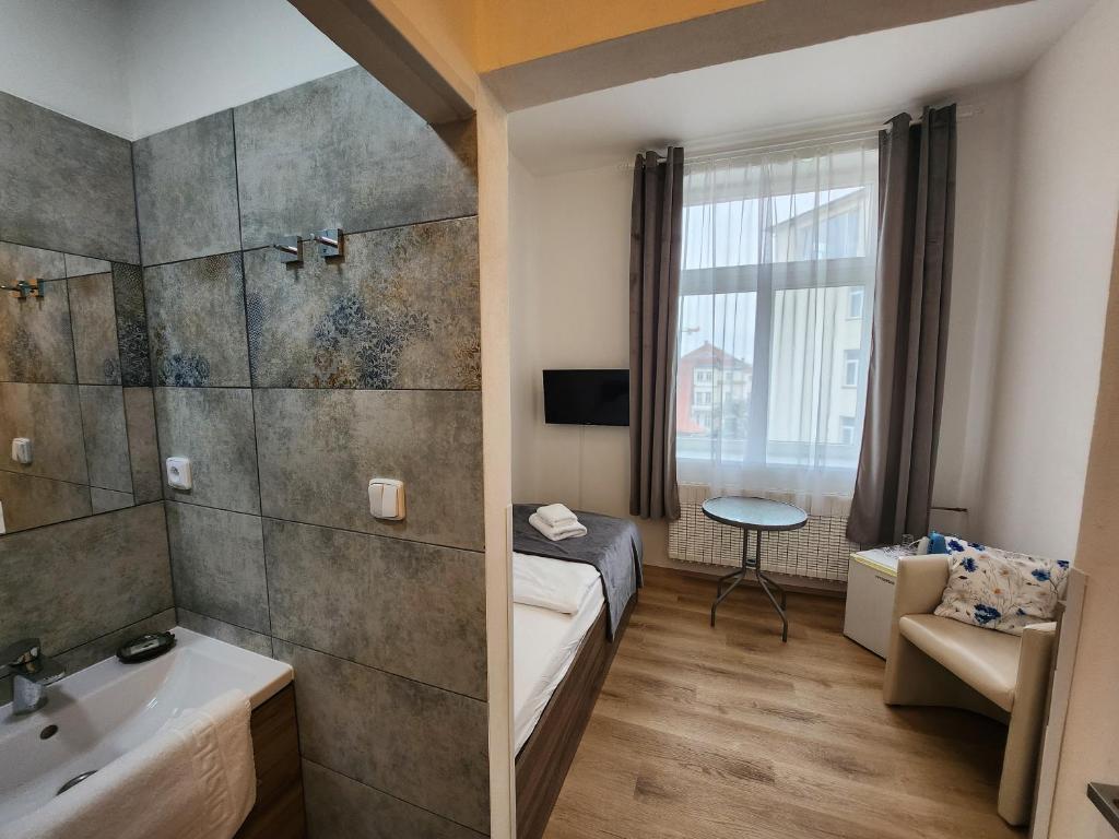 a hotel room with a bed and a bathroom at Penzion Alfa Poděbrady in Poděbrady