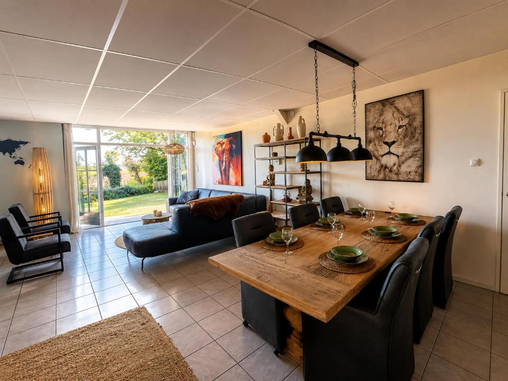 a living room with a large wooden table and chairs at Holiday Home de Binnengouw incl Hottub in Hoogwoud