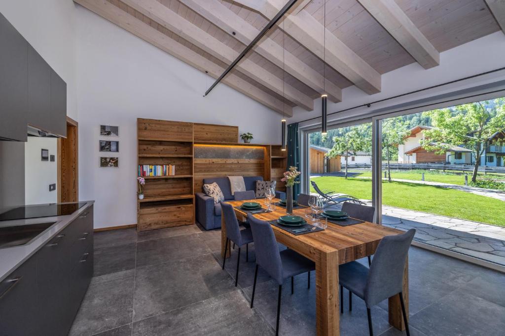 a kitchen and dining room with a wooden table and chairs at Shasta Mountain Lodge in Cavalese