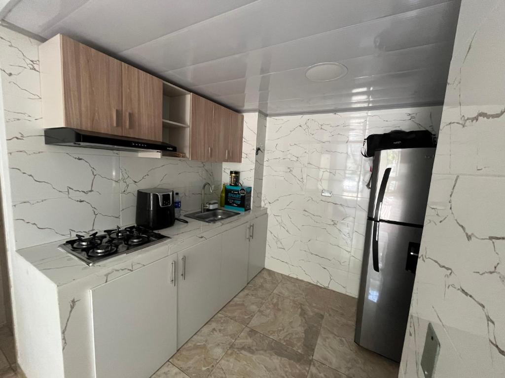 a kitchen with white cabinets and a refrigerator at Ciudad Guabinas in Yumbo
