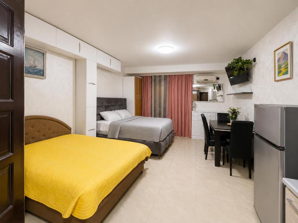 a hotel room with two beds and a dining table at Monetegro Seaside in Rafailovici