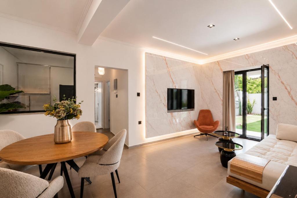 a living room with a table and a couch at Kayia City Garden, Luxury Suite with Private Garden in Heraklio