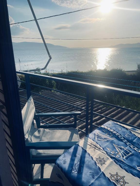 a view of the ocean from a balcony with two chairs at Magklaras Seaside Apartments in Néa Palátia