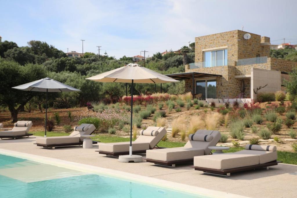 a group of chairs and an umbrella next to a pool at Villa Zeno in Tragána
