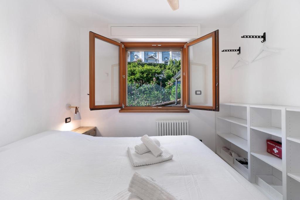 a bedroom with a white bed and a window at Lake Suite in Miasino