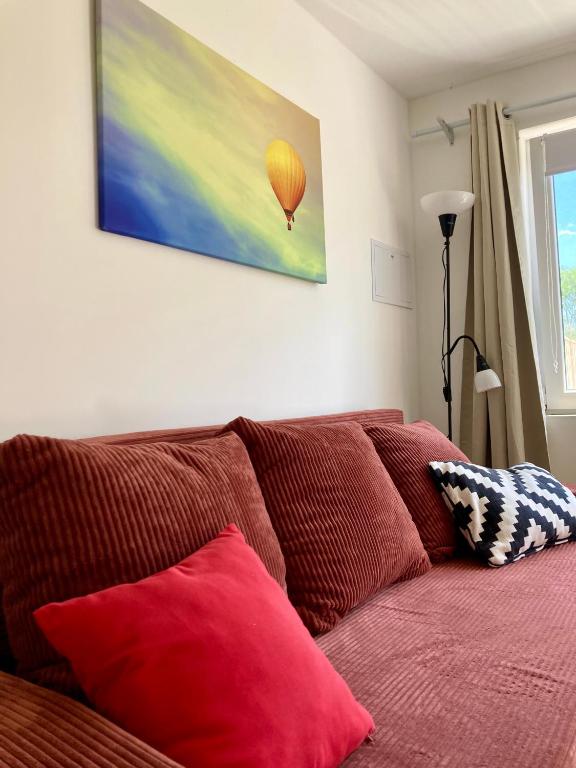 a couch with red pillows in a living room at Kisbirs Vendégház in Tokaj