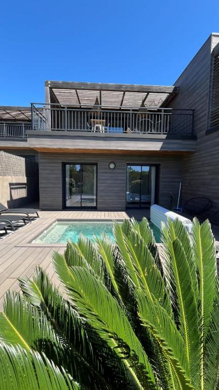 a house with a swimming pool in front of it at Luxurious Duplex With Pool Garden Balcony in Lecci