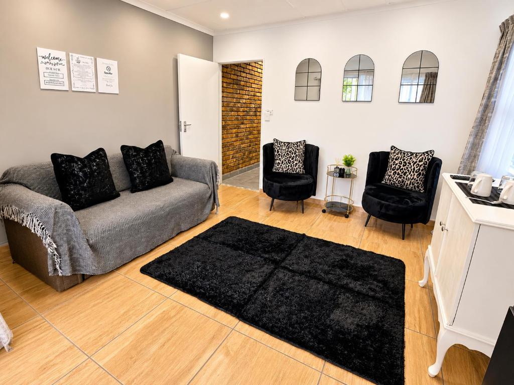a living room with a couch and two chairs at Zhantique Guest House 2- Unit 10 in Boksburg