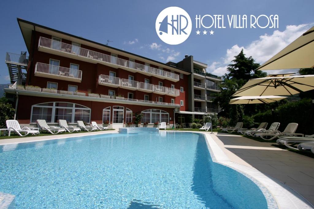 a hotel with a swimming pool in front of a building at Hotel Villa Rosa in Nago-Torbole