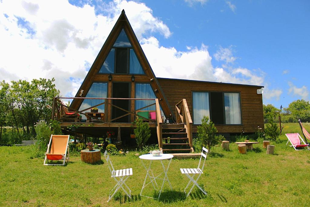 a house with a gambrel roof with a table and chairs at ''Sunflower'' in Dushetʼi