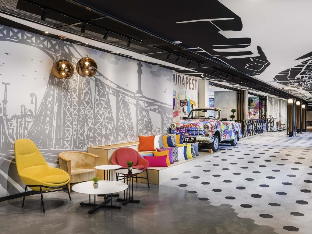 a store with colorful chairs and a car on the wall at Mercure Budapest Castle Hill in Budapest