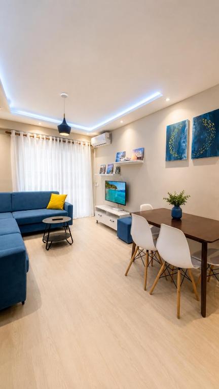 a living room with a blue couch and a table at Sirel Home in Durrës