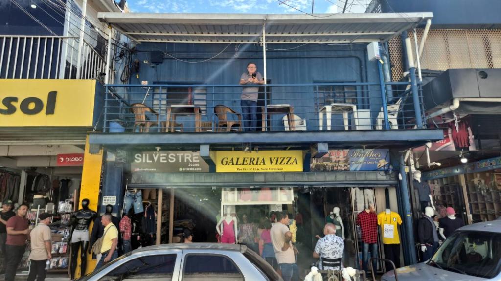 a woman standing on the balcony of a building at Hotel e Galeria Vizza in Goiânia