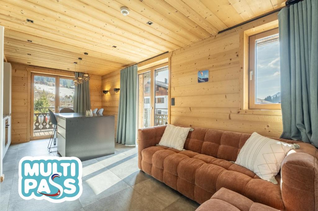 a living room with a couch and a desk at Appartement Gondola & Spa - MultiPass in Les Gets