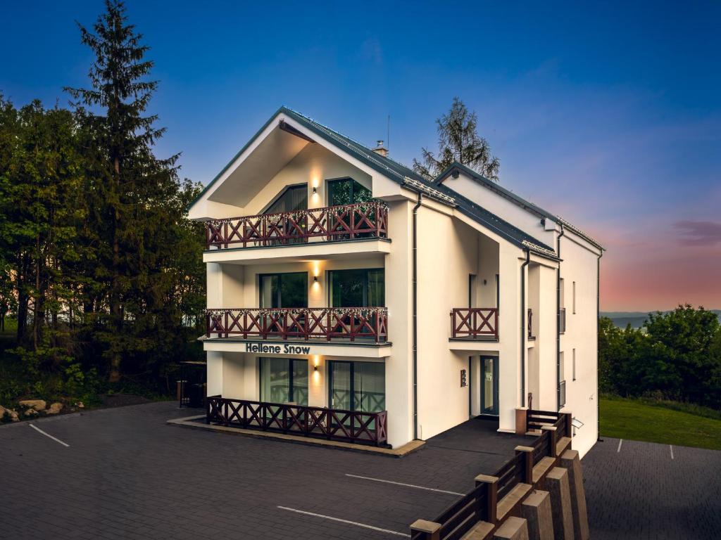 a white building with balconies on the side of it at Hellene Snow Starý Smokovec in Starý Smokovec