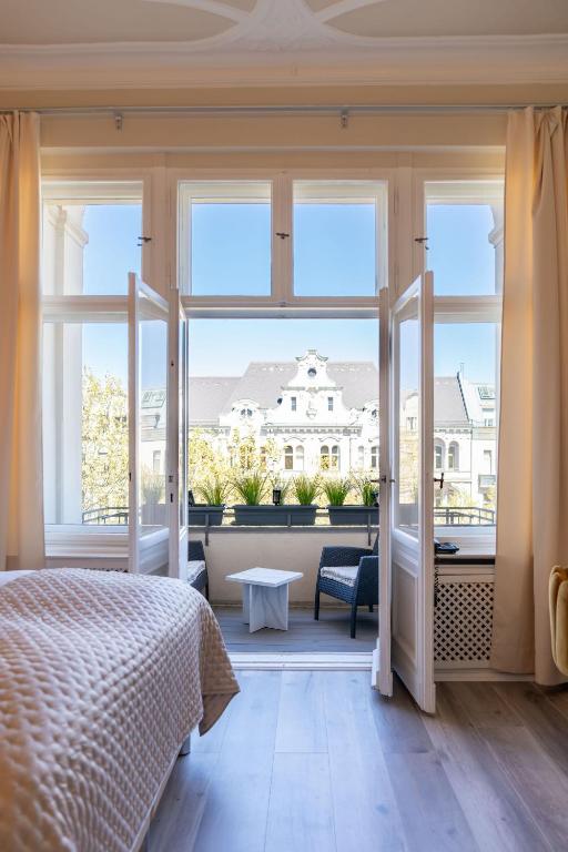 ein Schlafzimmer mit einem Bett und einem großen Fenster in der Unterkunft Hotel Augusta Am Kurfürstendamm in Berlin