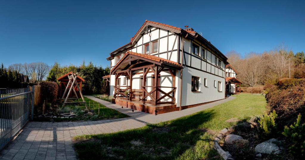 a small house with a playground in the yard at Zaciszna Przystań Dębina in Debina