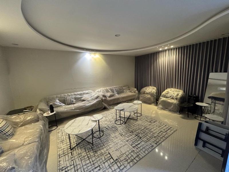a living room with a couch and two tables and chairs at شاليه إطلالة in Buraydah