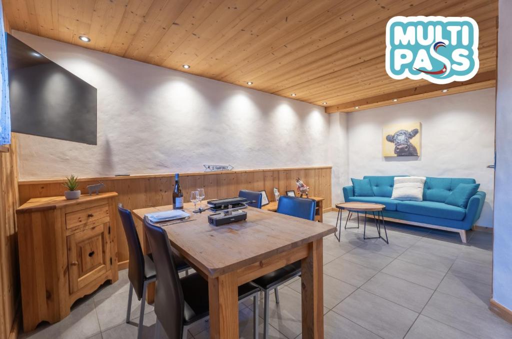 a restaurant with a table and a blue couch at Le Cosy - Appartement in Les Gets