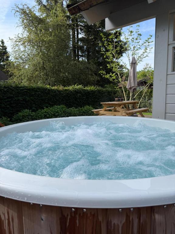 a jacuzzi tub in a backyard with a picnic table at Chalet Olive in Durbuy