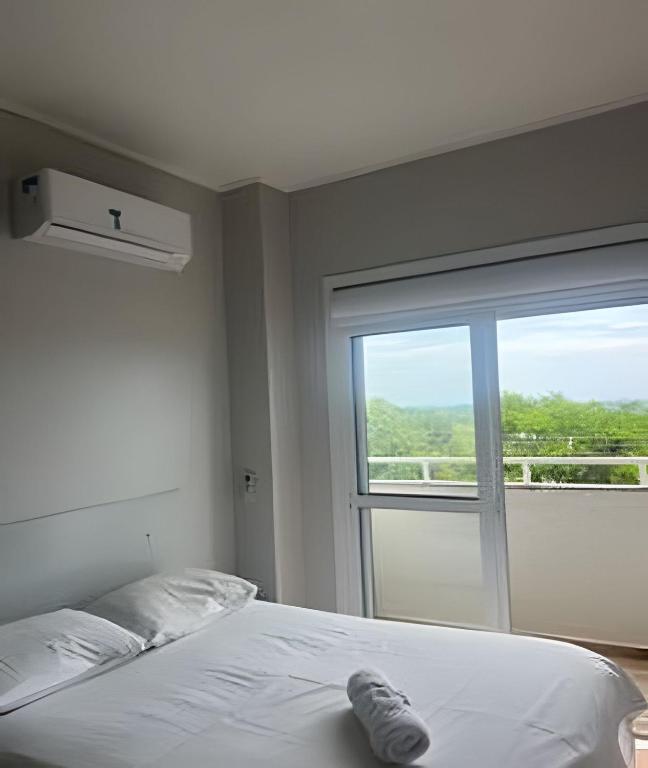 a bedroom with a bed and a large window at Apartamento - 2 Quartos * Completo * Central in Bento Gonçalves
