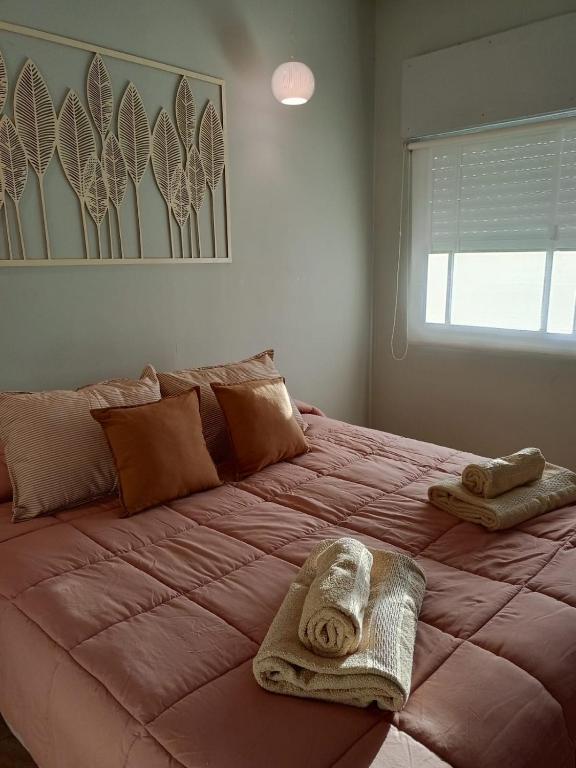 a large pink bed with towels on top of it at Con alma de Paraná, patio y estacionamiento propio in Paraná