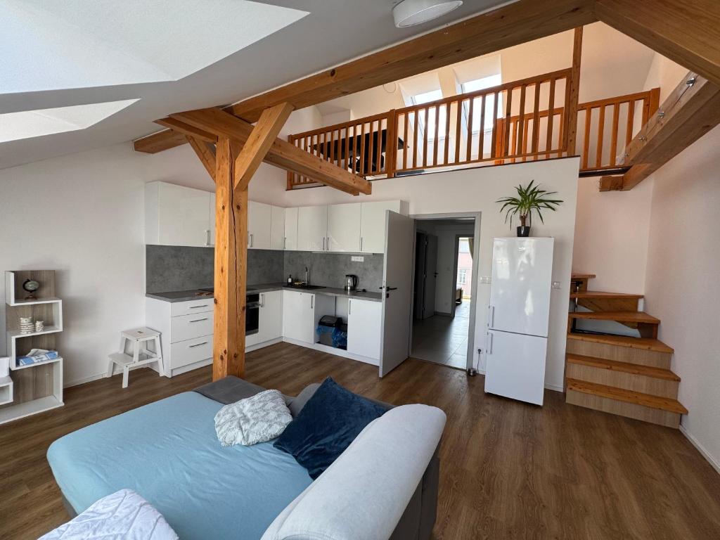 a living room with a blue couch and a staircase at StayCentralcz- Loft in Opava