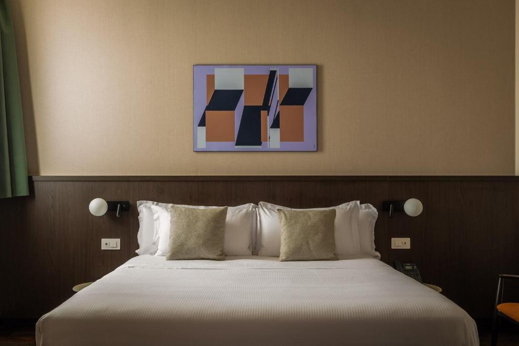 a bed with white sheets and pillows in a room at BYPILLOW Grand Central in Padova