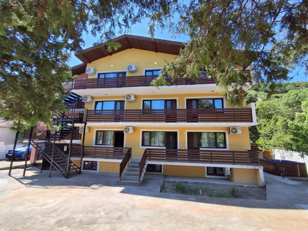 a large yellow building with stairs in front of it at Къща за гости Калабрия in Golden Sands