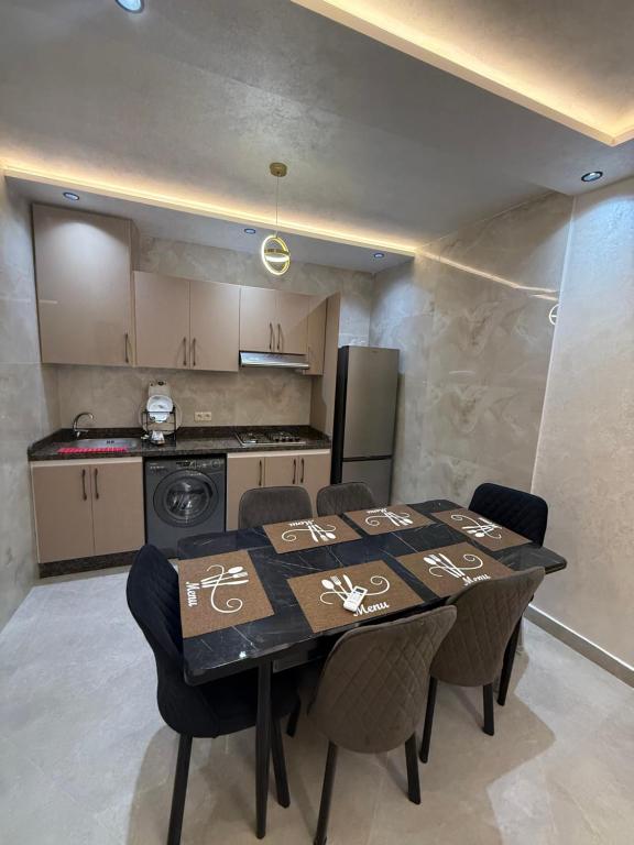 a dining room table with chairs and a kitchen at اقامة هبة 2 in Yebha