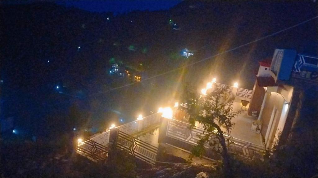a building with lights on top of it at night at Celestia peaks in Bhowāli