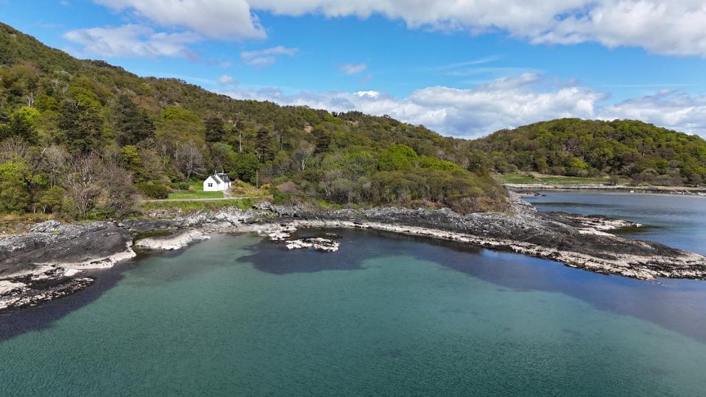an aerial view of a house on a rocky island in the water at The Kennels Ellary in Lochgilphead
