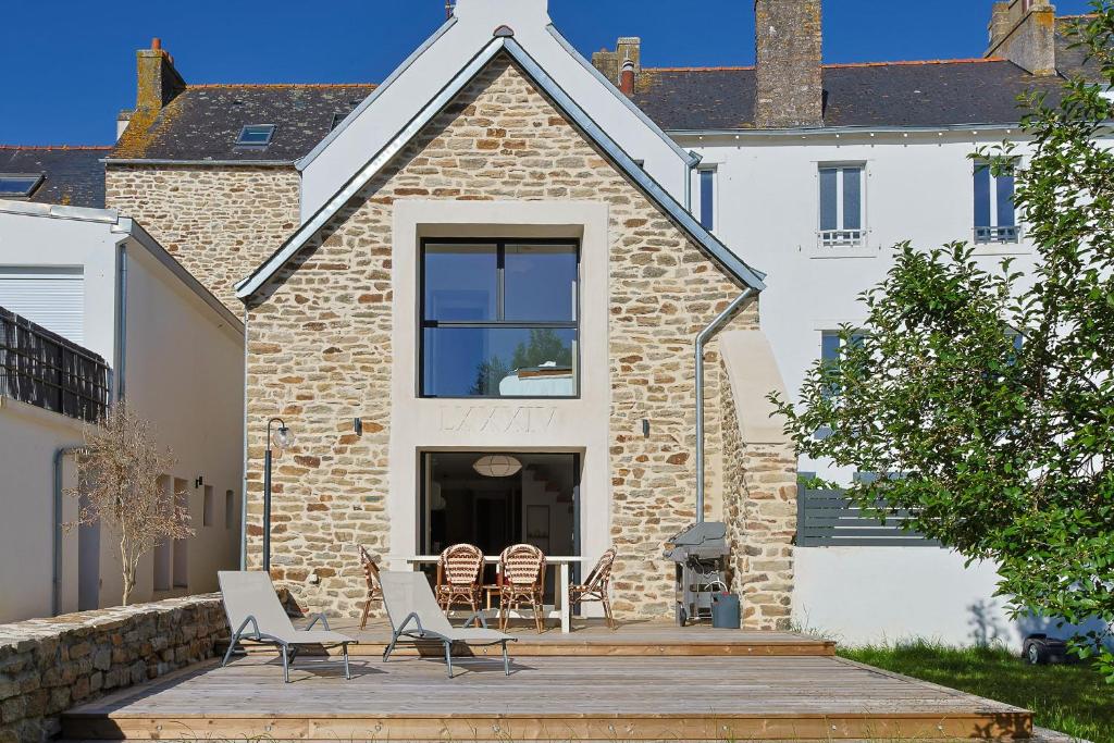 a house with chairs and a table on a patio at Maison VENELL Concarneau - Spa, Balnéo, Sauna & Jardin - Calme en Centre-ville in Concarneau