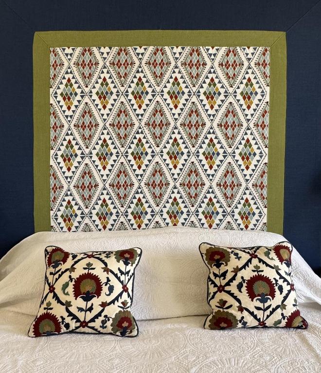 a bed with two pillows and a wall with a quilt at Loggos Harbour Suites in Longós
