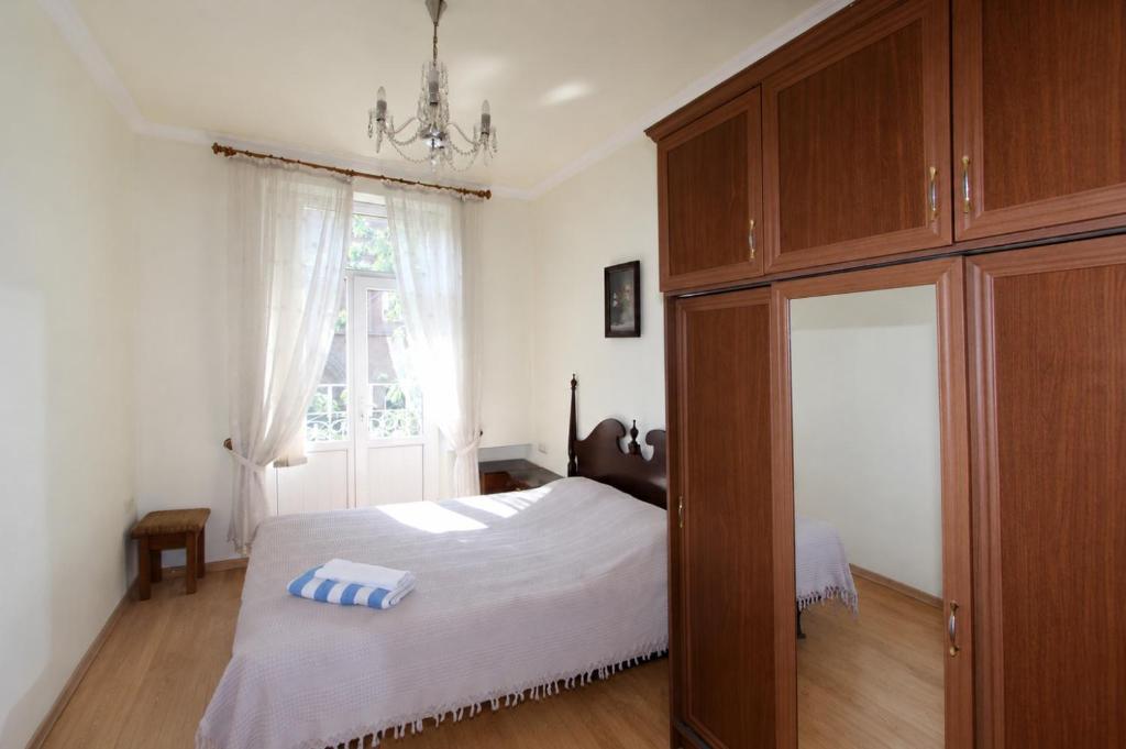 a bedroom with a bed and a large wooden cabinet at Large apartment by the Opera- luxury living room, 2 bedrooms, equipped kitchen and balcony in Yerevan