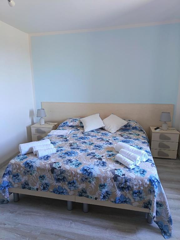 ein Schlafzimmer mit einem Bett mit einer blauen geblümten Tagesdecke in der Unterkunft Da Rita in Gerace