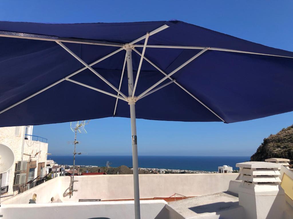 a blue umbrella with the ocean in the background at The Town House - Mojacar in Mojácar