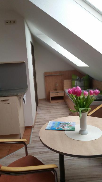 a living room with a table and a vase of flowers at Apartmenthaus Zwenkau in Zwenkau