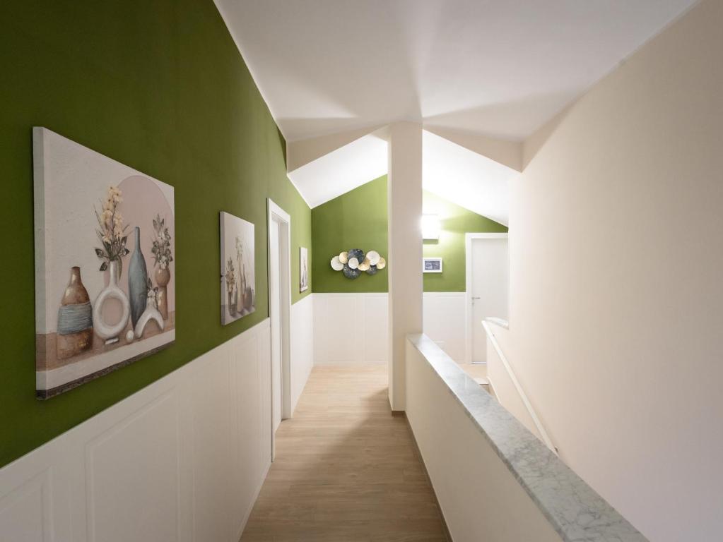 a hallway with green and white walls and wood floors at Le camere di Gaudré in Battipaglia