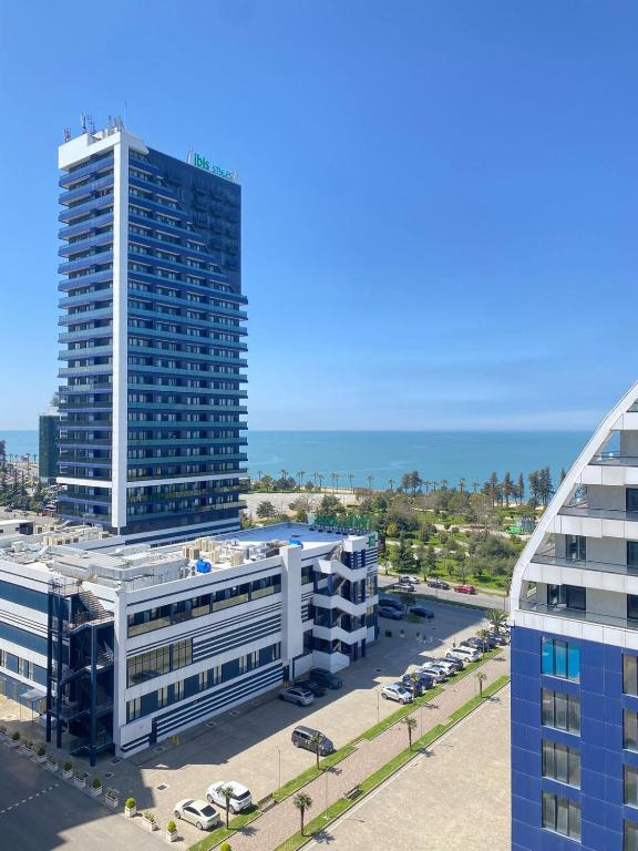 an aerial view of a tall building with a parking lot at Coastal Breeze Apartment in Batumi