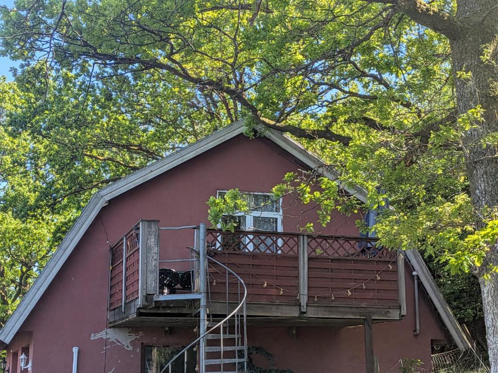 a dog sitting on a balcony of a red house at Vinds Våningen in Uddevalla