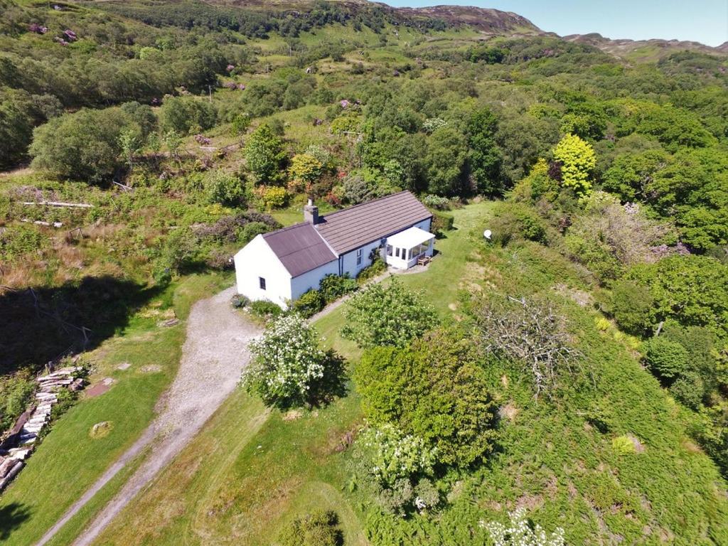 an aerial view of a small white house on a hill at Cove Cottage Ellary in Lochgilphead