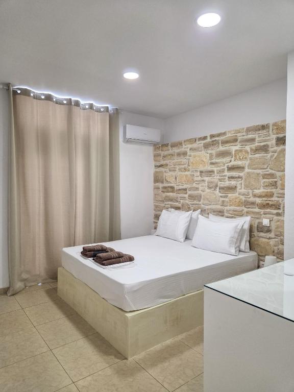a bedroom with a bed with a stone wall at Lithos Home Agia Galini in Agia Galini
