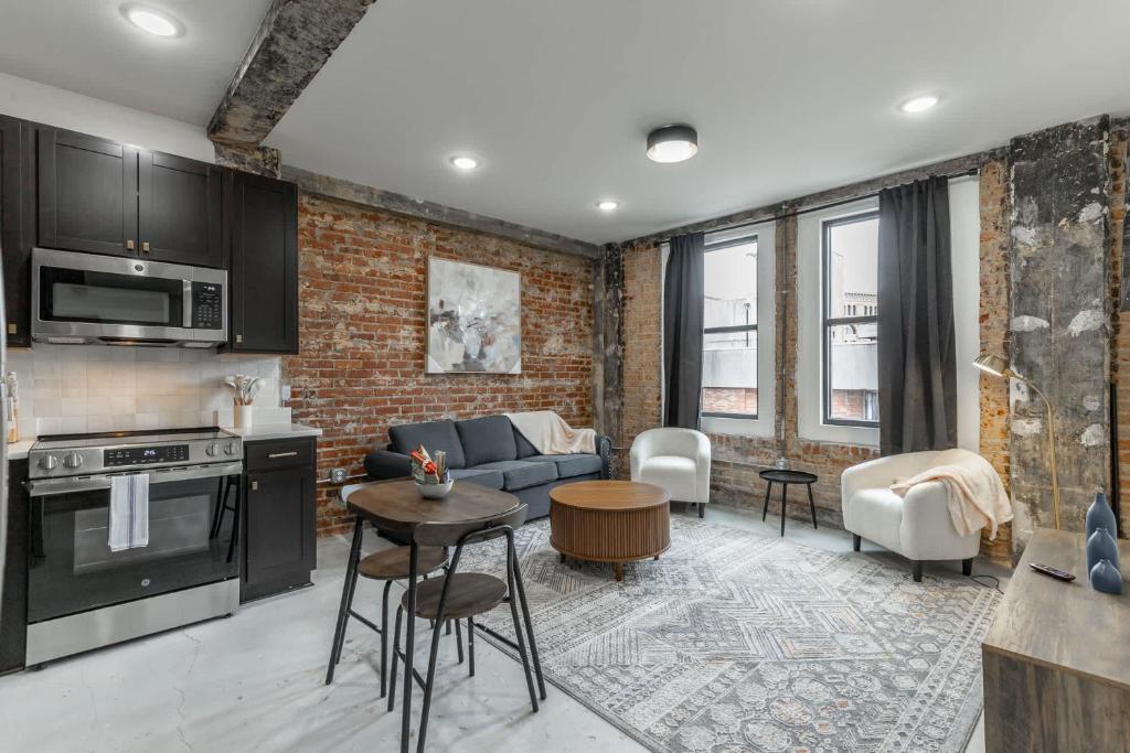 a kitchen and living room with a brick wall at Park Hotel 2BR Suite 306 in Chattanooga