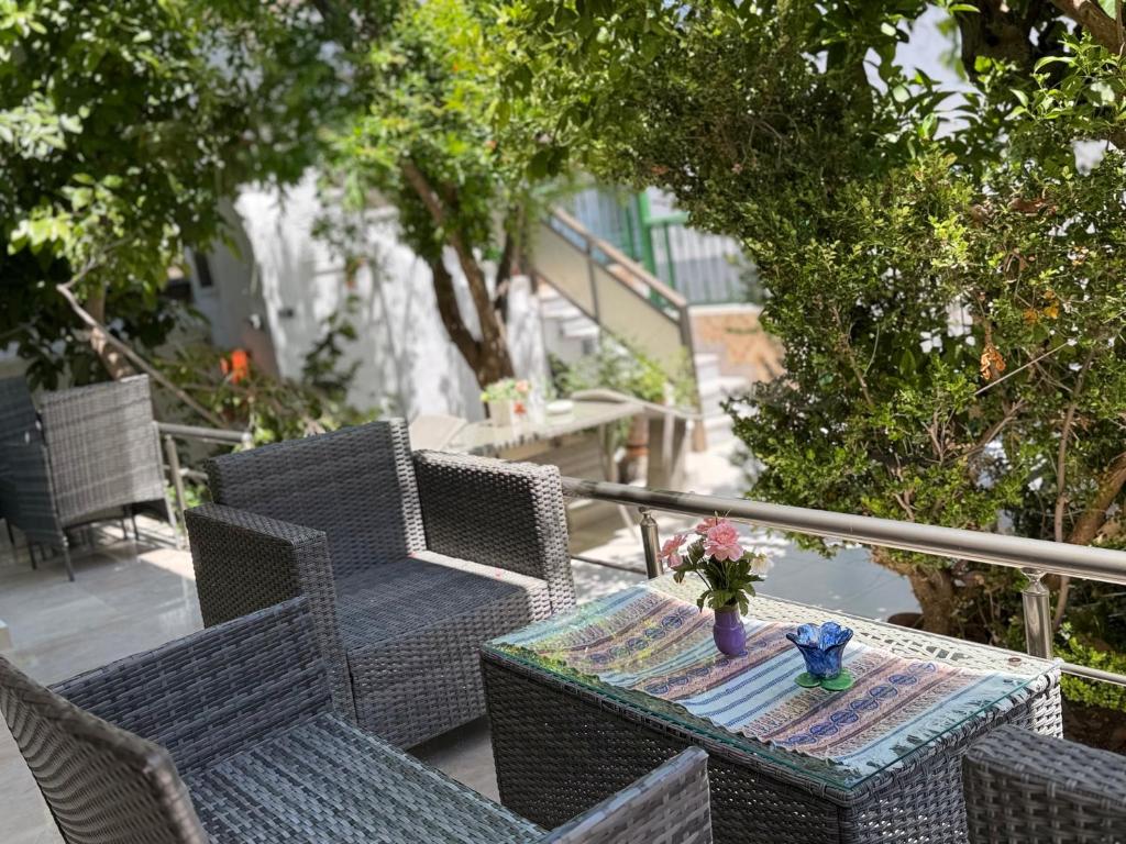 an outdoor table and chairs with a vase of flowers on it at Cleopatra's House Apartments in Archangelos