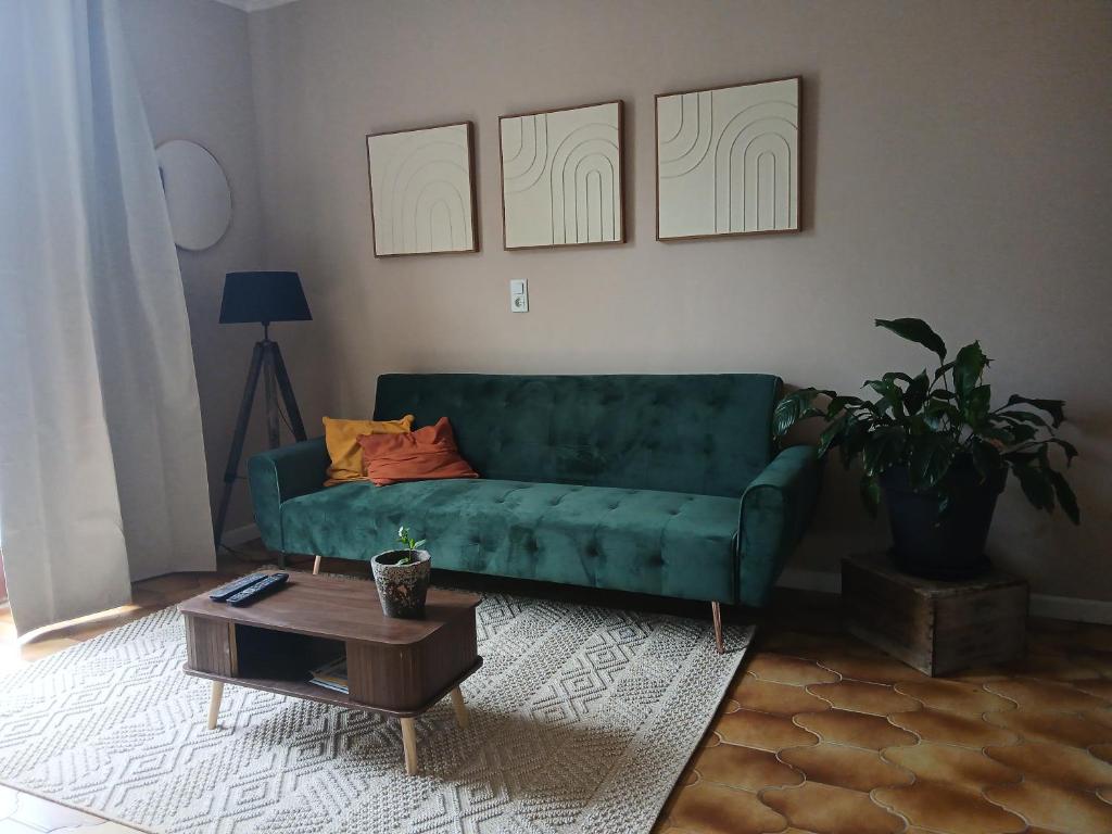 a green couch in a living room with a table at Sur l'Oneux in Hotton
