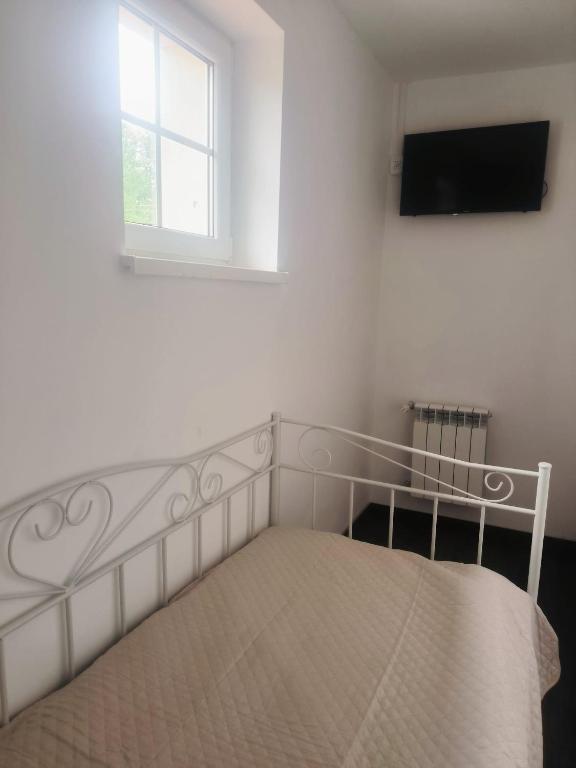 a bedroom with a bed and a window and a television at Dom Na Fali in Pasym