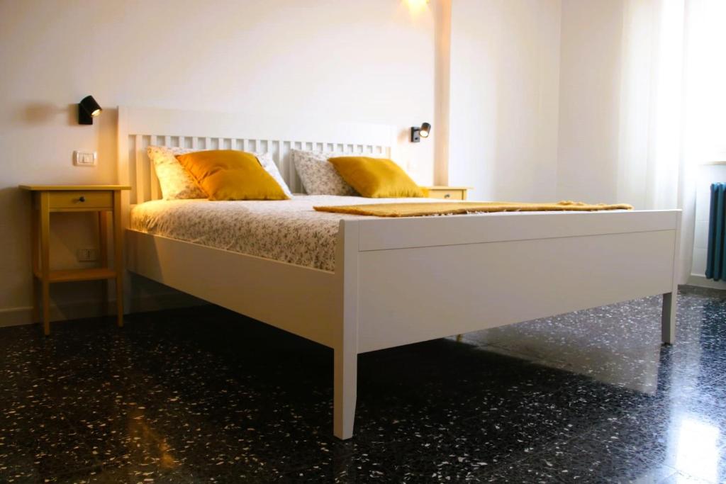 a white bed with yellow pillows in a bedroom at CASA IUCCI Langhe Monferrato in Canelli