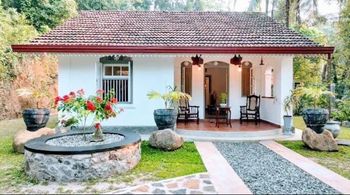 a small white house with a fountain in the yard at Calm Villa in Mihiripenne
