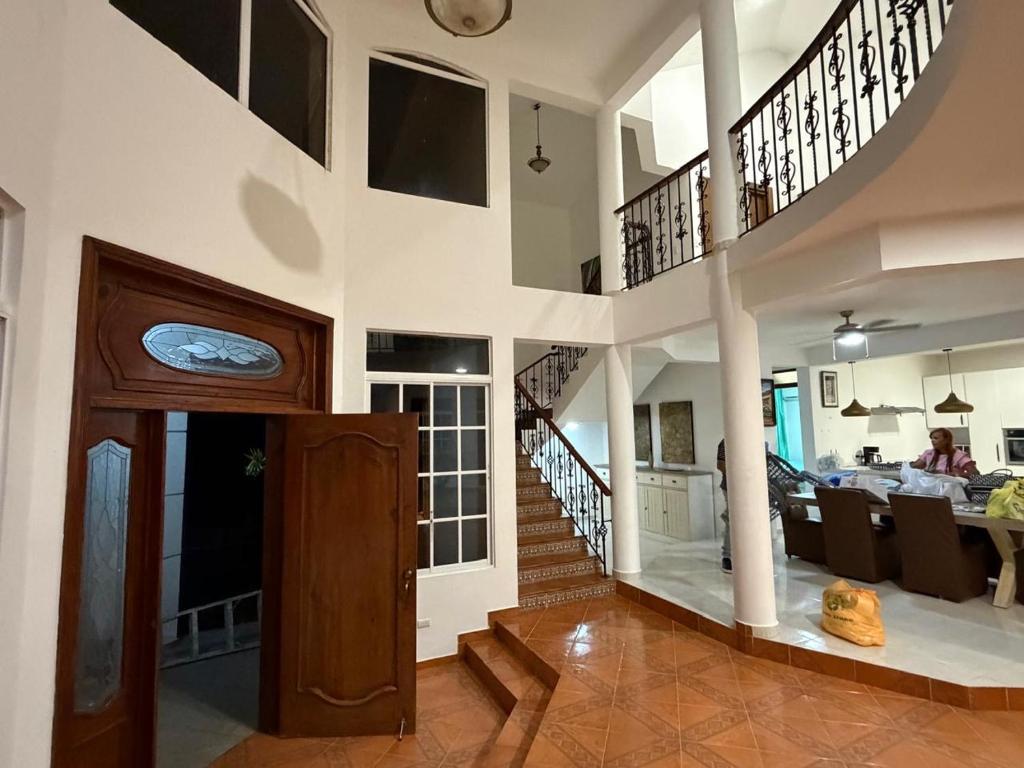 a living room with a staircase and a dining room at villa la dueña in San Felipe de Puerto Plata